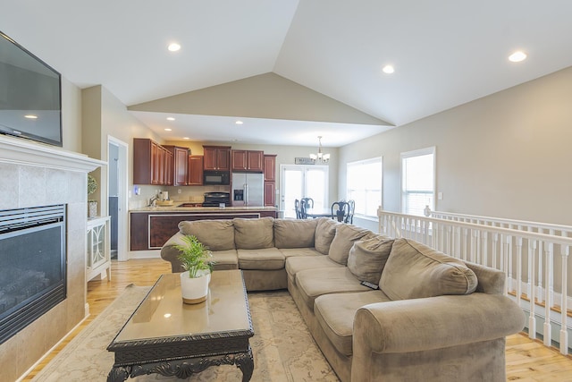 3224 Orchard Grass Rd, Lexington, KY 40509 - living area featuring a chandelier, light wood-type flooring, vaulted ceiling, a tile fireplace, and recessed lighting
