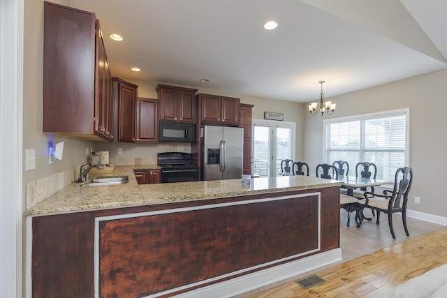 3224 Orchard Grass Rd, Lexington, KY 40509 - kitchen featuring black appliances, a chandelier, a peninsula, light wood-type flooring, and light stone countertops