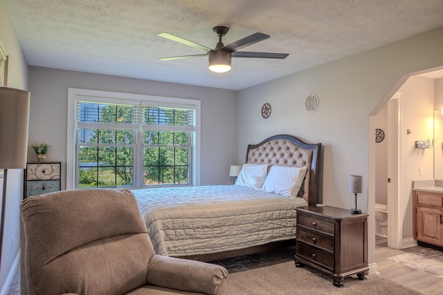 196 Herndon Ln, Berea, KY 40403 - bedroom featuring light wood-style floors, a textured ceiling, a ceiling fan, and ensuite bath