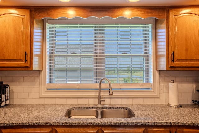 196 Herndon Ln, Berea, KY 40403 - kitchen with tasteful backsplash, brown cabinetry, and light stone countertops