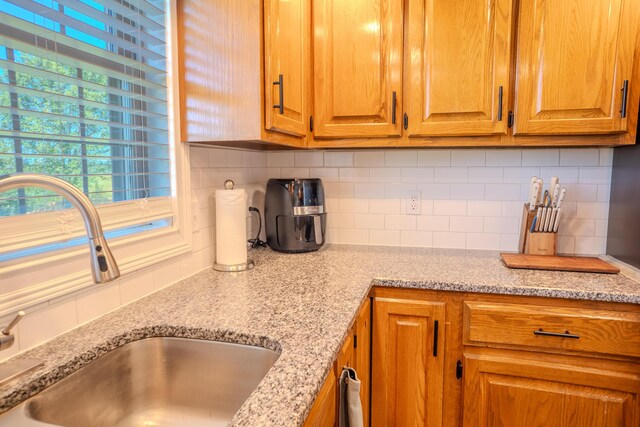 196 Herndon Ln, Berea, KY 40403 - kitchen featuring tasteful backsplash, brown cabinets, and light stone countertops