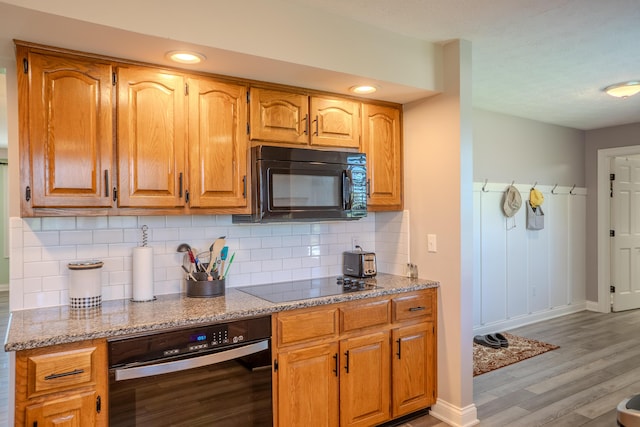 196 Herndon Ln, Berea, KY 40403 - kitchen with black appliances, light wood-style floors, tasteful backsplash, light stone countertops, and brown cabinets