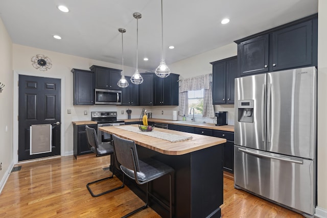 101 Rock Bridge Ct, Georgetown, KY 40324 - kitchen featuring stainless steel appliances, butcher block counters, a center island, a breakfast bar area, and light wood-type flooring