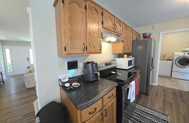10 Thaxted Ln, Middlesboro, KY 40965 - kitchen featuring under cabinet range hood, washer / dryer, stainless steel appliances, wood finished floors, and brown cabinets