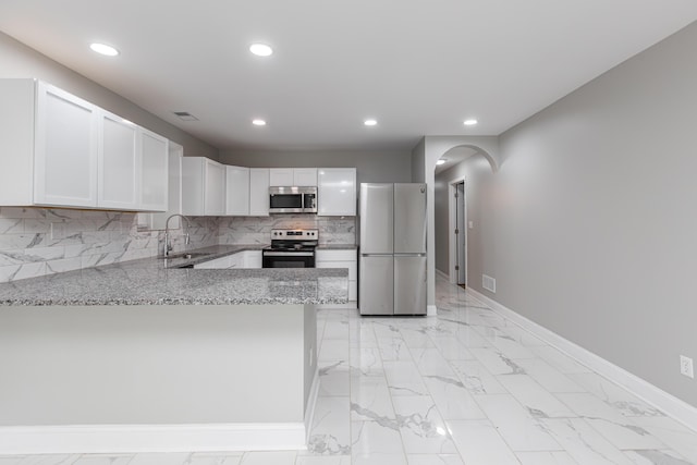 223 Race St, Lexington, KY 40508 - kitchen featuring appliances with stainless steel finishes, light stone countertops, a peninsula, recessed lighting, and white cabinetry