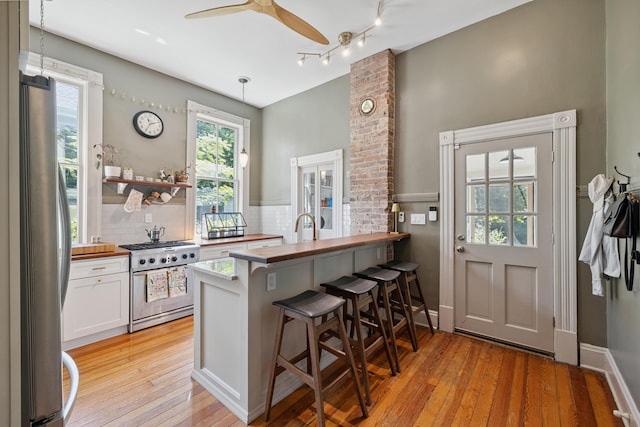 456 N Limestone St, Lexington, KY 40508 - kitchen with appliances with stainless steel finishes, wooden counters, light wood-style floors, white cabinets, and a breakfast bar area