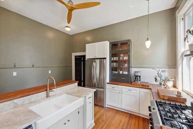 456 N Limestone St, Lexington, KY 40508 - kitchen with freestanding refrigerator, stove, light wood-style flooring, white cabinetry, and glass insert cabinets