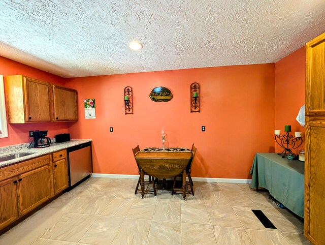 1260 Old Way Rd, London, KY 40741 - kitchen with stainless steel dishwasher, brown cabinets, a textured ceiling, light marble finish flooring, and recessed lighting