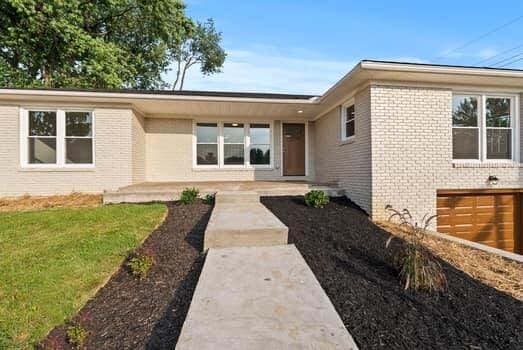 1142 Kiowa Trl, Frankfort, KY 40601 - doorway to property with brick siding, a garage, and a yard