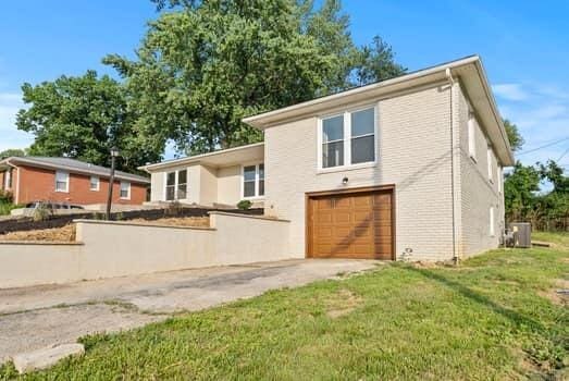 1142 Kiowa Trl, Frankfort, KY 40601 - back of house featuring a garage, driveway, and a lawn