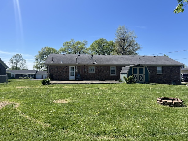 525 Scenic Dr, Harrodsburg, KY 40330 - back of house with an outdoor fire pit, a storage unit, brick siding, and a lawn