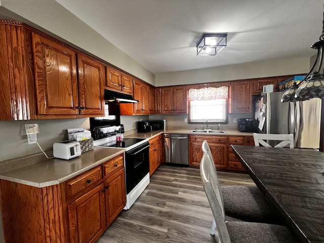 525 Scenic Dr, Harrodsburg, KY 40330 - kitchen with appliances with stainless steel finishes, dark wood-style flooring, under cabinet range hood, and brown cabinetry