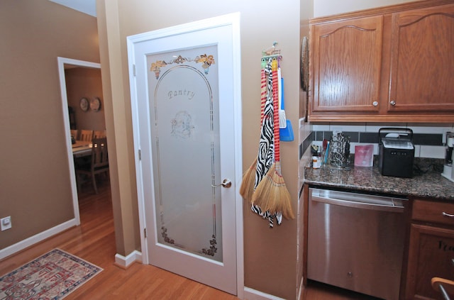 1016 Cedar Ridge Ln, Versailles, KY 40383 - kitchen with stainless steel dishwasher, light wood finished floors, brown cabinetry, and dark stone counters