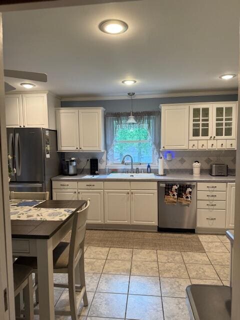 1310 Lago Dr, Frankfort, KY 40601 - kitchen with stainless steel dishwasher, freestanding refrigerator, white cabinets, backsplash, and ornamental molding