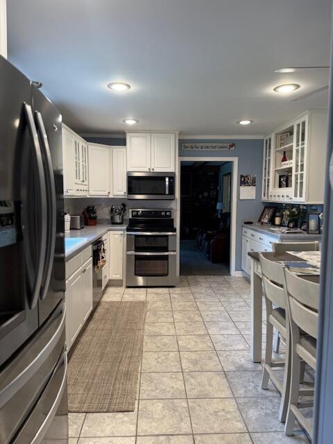 1310 Lago Dr, Frankfort, KY 40601 - kitchen with appliances with stainless steel finishes, white cabinetry, glass insert cabinets, light countertops, and recessed lighting