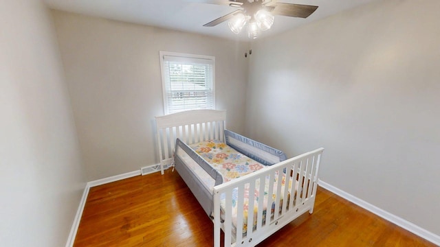 1010 Riverside Dr, Harrodsburg, KY 40330 - bedroom featuring wood finished floors, a ceiling fan, and a crib