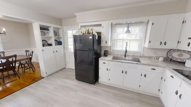 1010 Riverside Dr, Harrodsburg, KY 40330 - kitchen with freestanding refrigerator, light countertops, light wood-type flooring, white cabinets, and crown molding