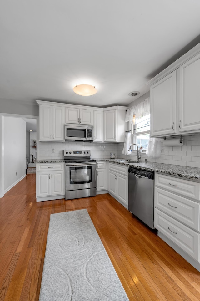 2864 Ark Royal Way, Lexington, KY 40503 - kitchen featuring appliances with stainless steel finishes, backsplash, light wood-style flooring, and white cabinets
