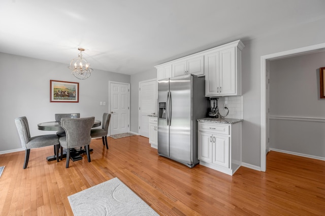2864 Ark Royal Way, Lexington, KY 40503 - kitchen featuring stainless steel fridge with ice dispenser, white cabinets, a chandelier, light wood-style floors, and decorative backsplash
