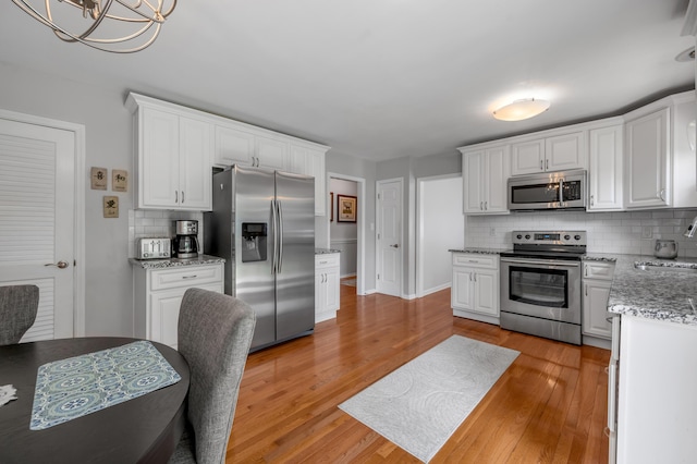 2864 Ark Royal Way, Lexington, KY 40503 - kitchen with stainless steel appliances, decorative backsplash, white cabinetry, and light wood-style flooring