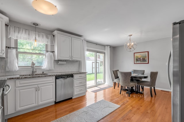 2864 Ark Royal Way, Lexington, KY 40503 - kitchen with stainless steel appliances, decorative backsplash, light stone countertops, white cabinetry, and light wood finished floors