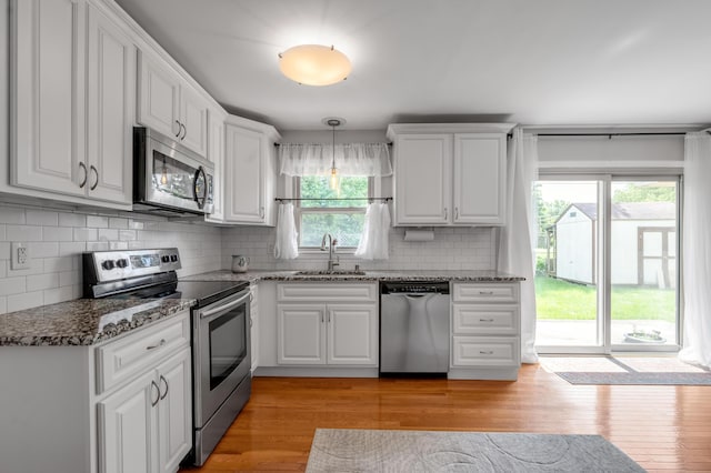 2864 Ark Royal Way, Lexington, KY 40503 - kitchen featuring stainless steel appliances, white cabinets, light wood-type flooring, backsplash, and stone countertops