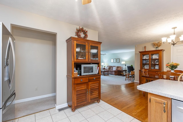206 Candlewood Dr, Danville, KY 40422 - kitchen with stainless steel fridge with ice dispenser, white microwave, light countertops, a chandelier, and light carpet