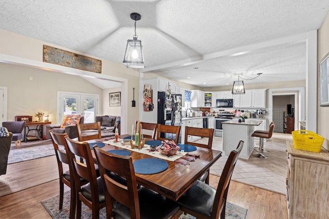 997 Copper Creek Rd, Berea, KY 40403 - dining space with healthy amount of natural light, a textured ceiling, light wood-style floors, vaulted ceiling, and french doors