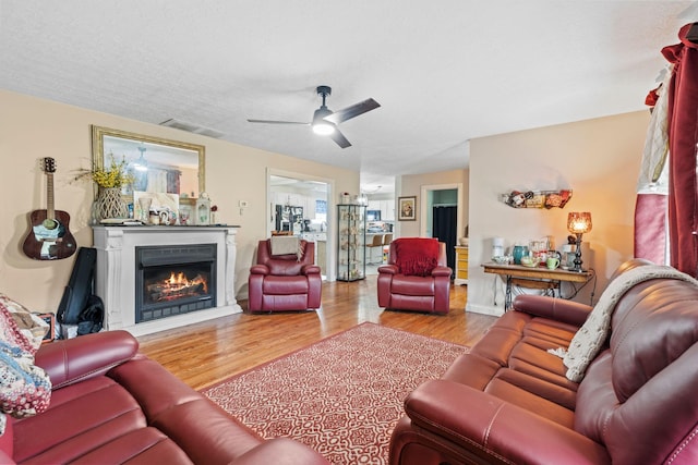 997 Copper Creek Rd, Berea, KY 40403 - living area with a lit fireplace, wood finished floors, and ceiling fan
