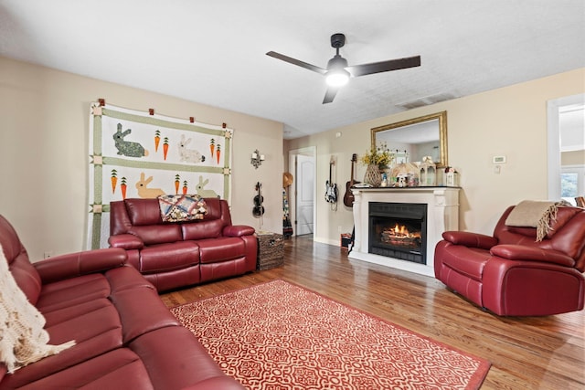 997 Copper Creek Rd, Berea, KY 40403 - living room featuring wood finished floors, a warm lit fireplace, and a ceiling fan