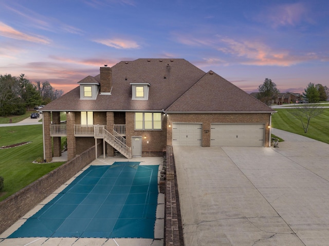 117 Richland Dr, Richmond, KY 40475 - back of property at dusk featuring an attached garage, a lawn, a chimney, and roof with shingles