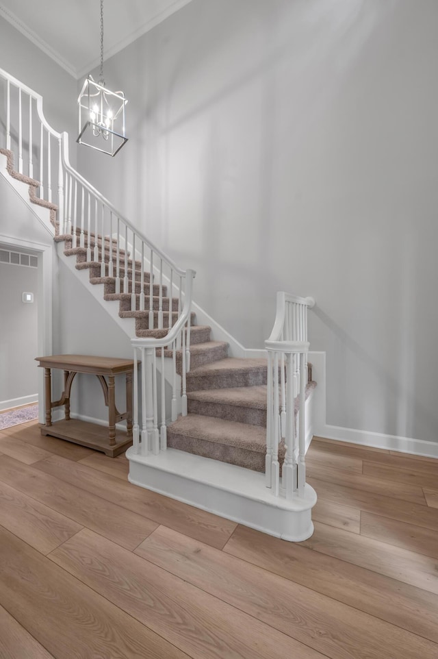 1074 Rockbridge Rd, Lexington, KY 40515 - stairway with crown molding, wood finished floors, and a chandelier
