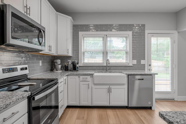 1074 Rockbridge Rd, Lexington, KY 40515 - kitchen featuring stainless steel appliances, light wood-style flooring, backsplash, and white cabinets