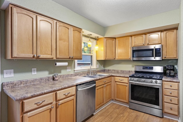3523 Brookview Dr, Lexington, KY 40517 - kitchen featuring appliances with stainless steel finishes, light wood-style floors, a textured ceiling, hanging light fixtures, and light countertops