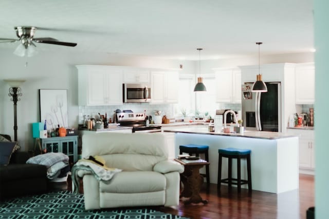 585 Cotton Rd, Corbin, KY 40701 - kitchen with stainless steel appliances, open floor plan, decorative backsplash, and dark wood-style floors
