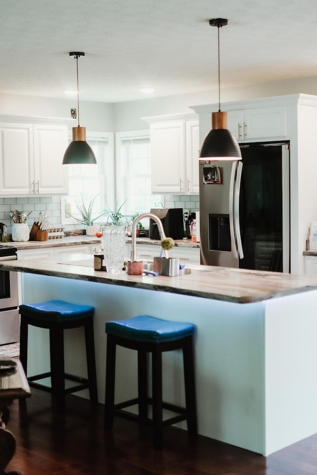 585 Cotton Rd, Corbin, KY 40701 - kitchen featuring refrigerator with ice dispenser, stainless steel electric range oven, backsplash, and white cabinets