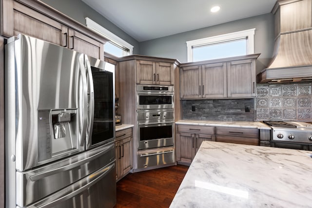 60 Pilots Dream Dr, Dry Ridge, KY 41035 - kitchen featuring stainless steel appliances, a warming drawer, tasteful backsplash, light stone counters, and custom exhaust hood