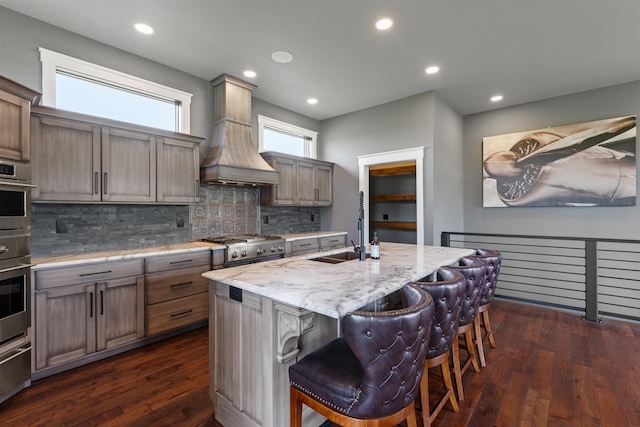 60 Pilots Dream Dr, Dry Ridge, KY 41035 - kitchen featuring custom exhaust hood, decorative backsplash, dark wood-style flooring, a center island with sink, and light stone counters