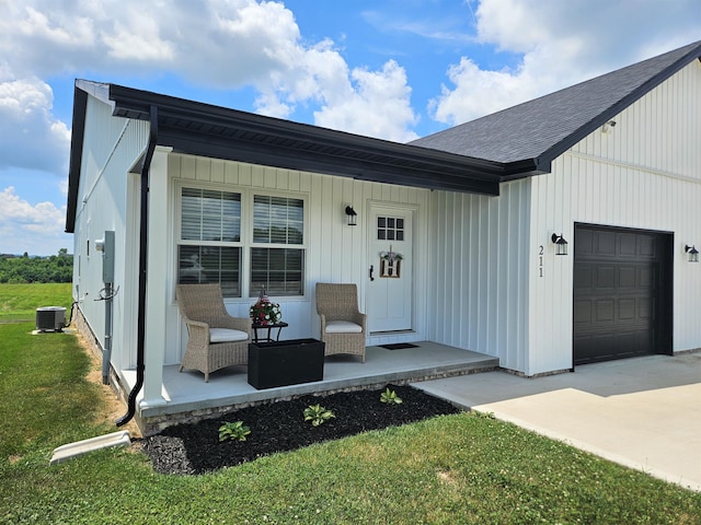 209-211 Wyldwood Way, Berea, KY 40403 - doorway to property with covered porch, a garage, a shingled roof, a yard, and concrete driveway