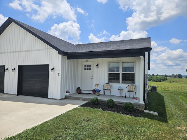 209-211 Wyldwood Way, Berea, KY 40403 - view of front of property featuring a porch, a shingled roof, a front yard, driveway, and a garage