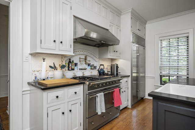321 S Turner St, Midway, KY 40347 - kitchen with premium appliances, ventilation hood, dark countertops, backsplash, and white cabinets