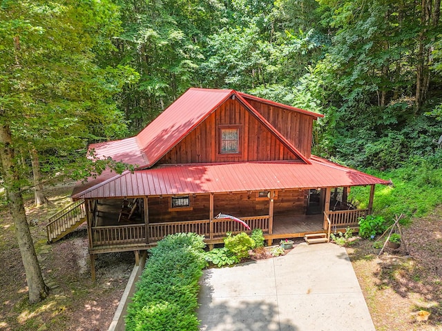 843 Joe Henson Rd, Dunnville, KY 42528 - view of front of house featuring a forest view, covered porch, board and batten siding, and a metal roof