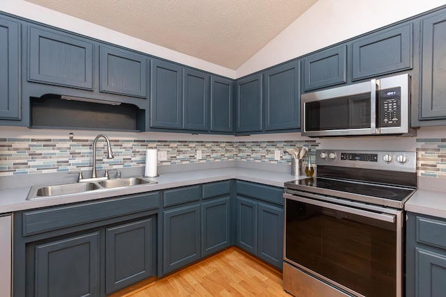129 Plantation Dr, Lawrenceburg, KY 40342 - kitchen with appliances with stainless steel finishes, vaulted ceiling, light countertops, tasteful backsplash, and blue cabinetry