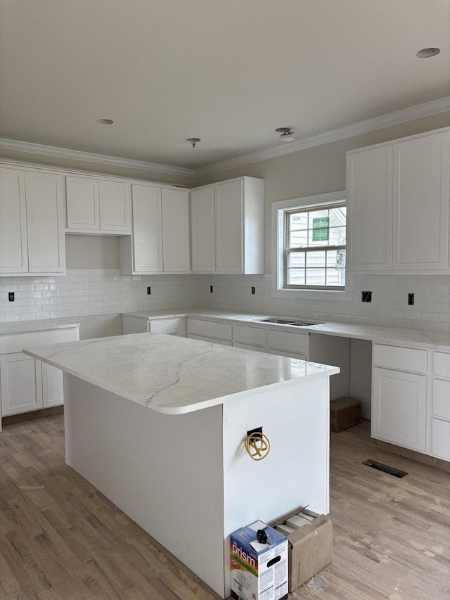 2716 Kearney Creek Ln, Lexington, KY 40511 - kitchen with ornamental molding, backsplash, light stone counters, light wood-style flooring, and white cabinetry