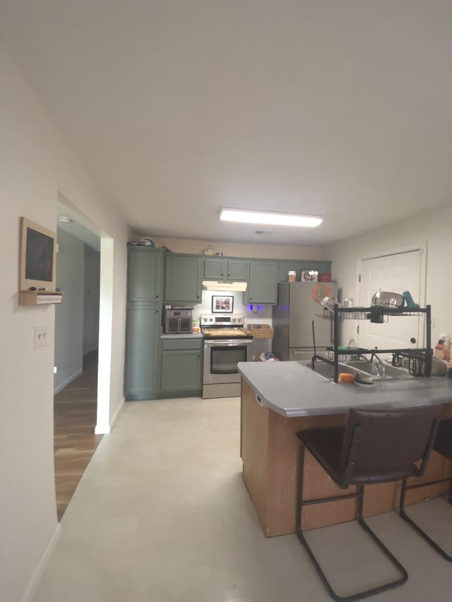 3004 Bell Ct, Richmond, KY 40475 - kitchen with appliances with stainless steel finishes, under cabinet range hood, a kitchen breakfast bar, and green cabinetry
