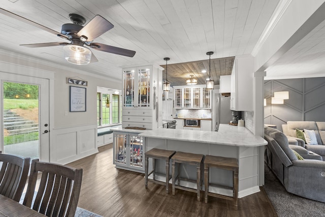1020 Cornish Ln, Lawrenceburg, KY 40342 - kitchen with a peninsula, stainless steel appliances, a breakfast bar, white cabinets, and ornamental molding