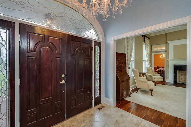 1758 Airdrie Ln, Frankfort, KY 40601 - foyer entrance with a chandelier, a fireplace with flush hearth, and light wood finished floors