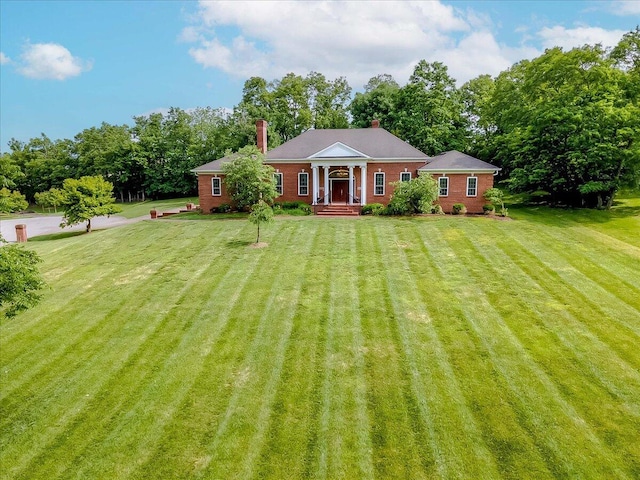 1758 Airdrie Ln, Frankfort, KY 40601 - greek revival inspired property featuring a front lawn, a chimney, brick siding, and view of wooded area