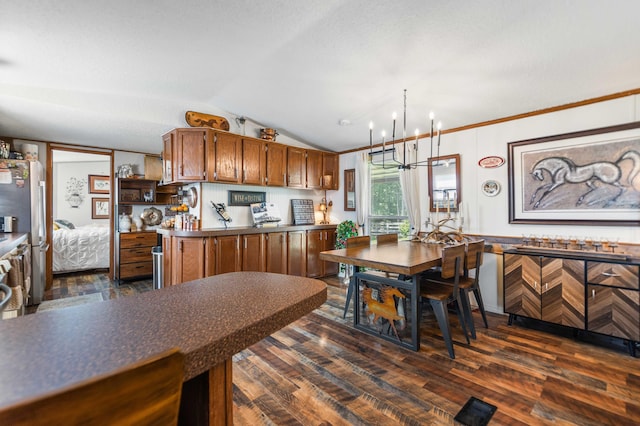 1100 Doublegate Rd, Jeffersonville, KY 40337 - kitchen with lofted ceiling, dark wood-style floors, a chandelier, brown cabinetry, and freestanding refrigerator