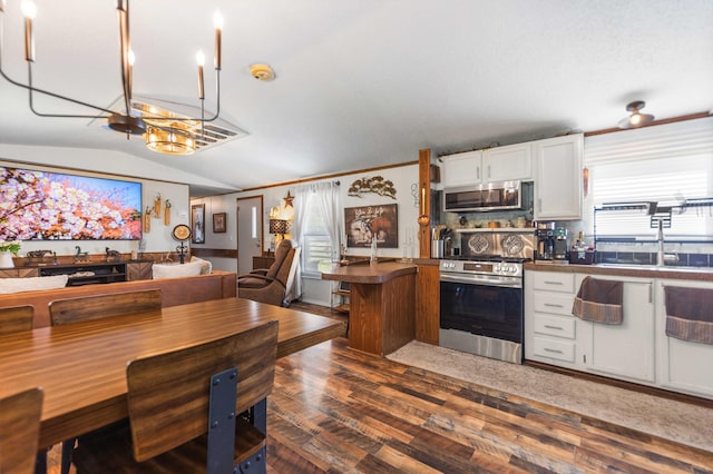 1100 Doublegate Rd, Jeffersonville, KY 40337 - kitchen featuring appliances with stainless steel finishes, dark countertops, wood finished floors, open floor plan, and white cabinetry
